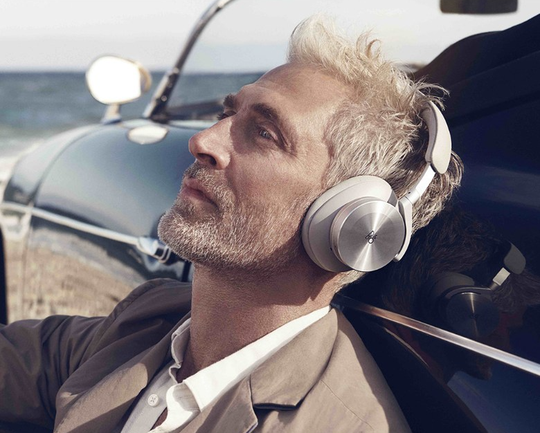 An image of a man wearing bang and olufson noise beoplay H95 cancelling headphones